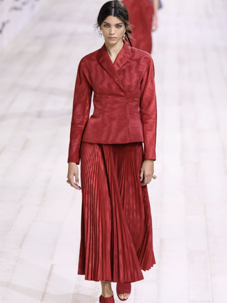 Модель в красном костюме на показе Dior Haute Couture