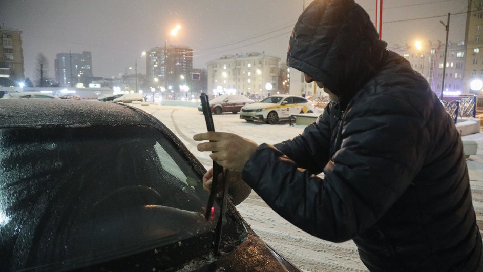 Мужчина проверяет дворники Мужчина проверяет дворники