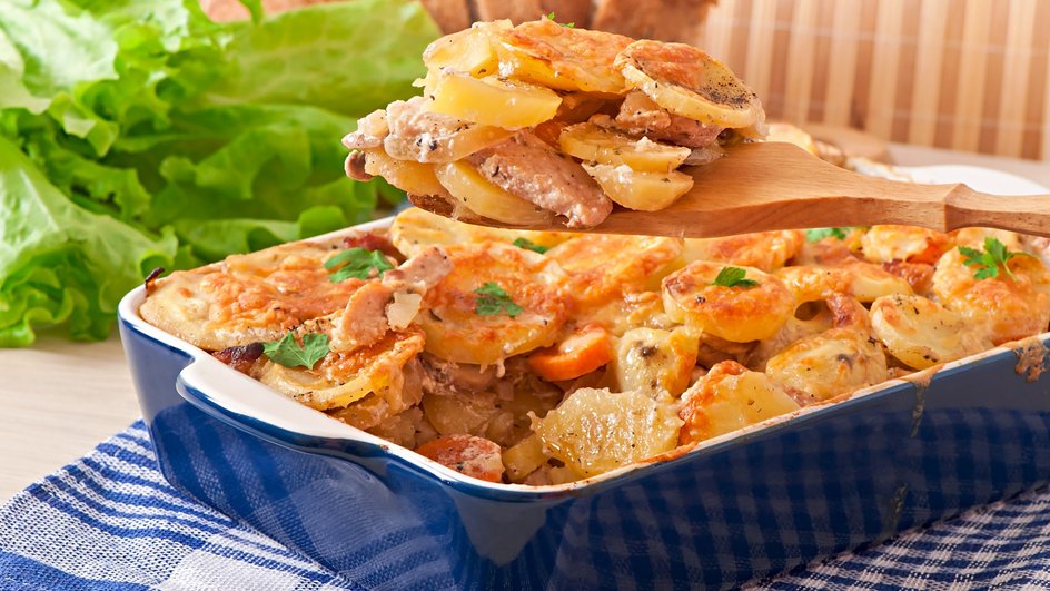 Мясо по-французски с соусом бешамель лежит в блюде на столе