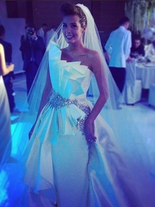 Slide image for gallery: 3232 | Комментарий lady.mail.ru: На этот раз Кэти решила выглядеть как настоящая невеста – с фатой, букетом, в белом платье… Однако наряд она все же выбрала в своем стиле – довольно футуристичный