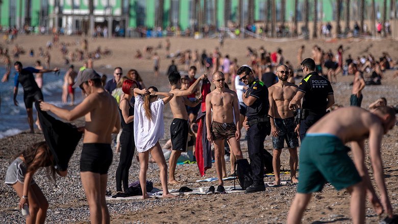 Полицейские просят людей не сидеть на пляже в Барселоне. 20 мая в Барселоне разрешили людям посещать пляжи, но загорать и отдыхать на них по-прежнему запрещено