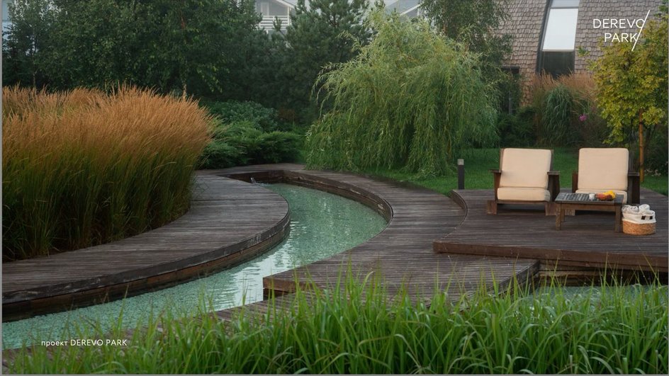 Ландшафтный дизайн с двумя креслами, деревянным настилом и искусственным водоем