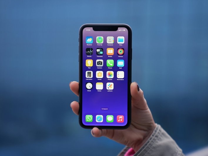 Пользователь держит в руках iPhone и собирается сделать скриншот экрана Пользователь держит в руках iPhone и собирается сделать скриншот экрана