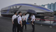 Workers chat near a 600km/h High Speed Maglev model as they wait for arrival of the delegates at the National Railway Test Center during the World Congress on High-Speed Rail held in Beijing, Wednesday, July 9, 2025. (AP Photo/Andy Wong)