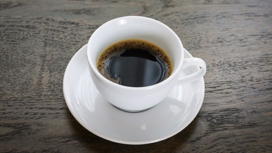 Белая чашка с кофе на столе