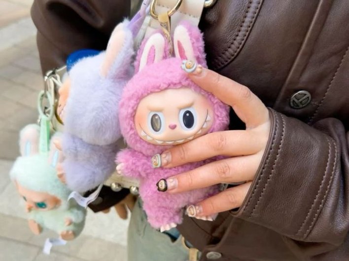 Девушка с игрушками Labubu на сумке Девушка с игрушками Labubu на сумке