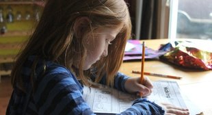 girl-drawing-on-brown-wooden-table-1001675.jpg