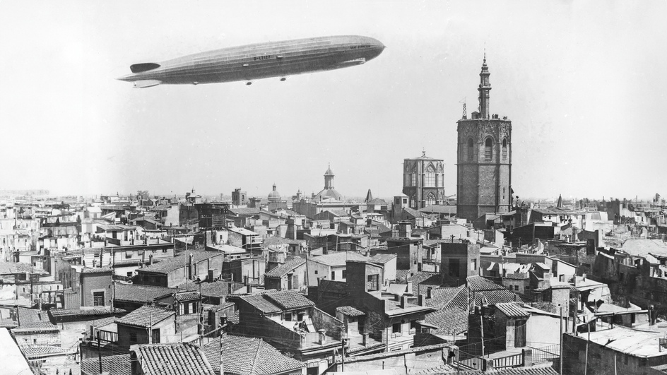 Дирижабль Zeppelin пролетает над городом в 1929 году.