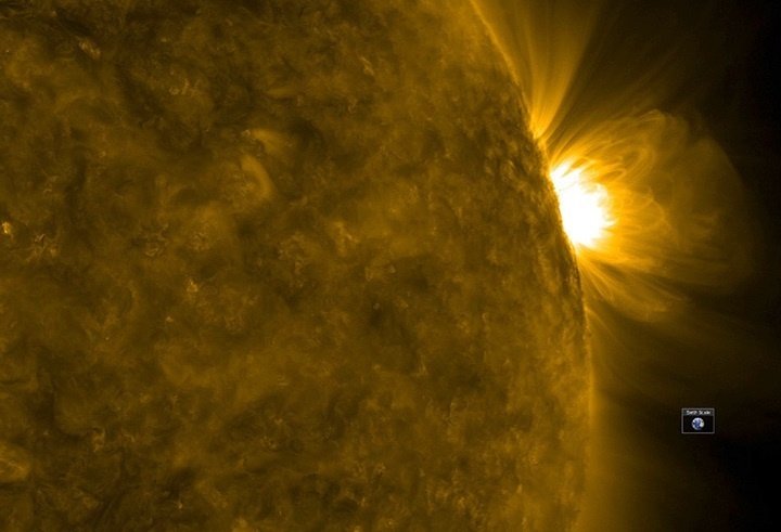 Часть Солнца и маленькая Земля на фоне звезды. Картинка: Solar Dynamics Observatory