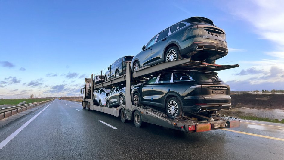 Новые Chery Tiggo 9 везут на автовозе в Москву по трассе М4