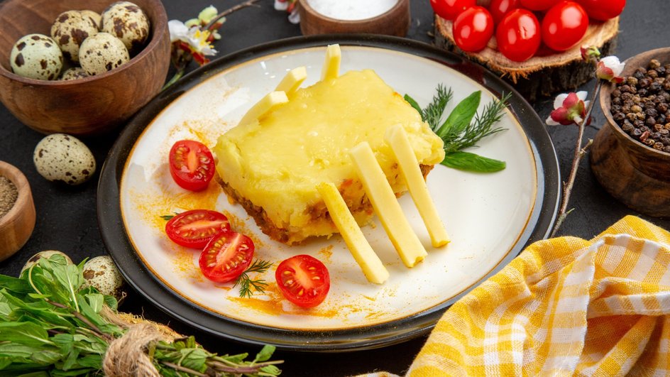 Мясо по-французски из говядины, приготовленное в мультиварке, лежит на тарелке рядом с ингредиентами
