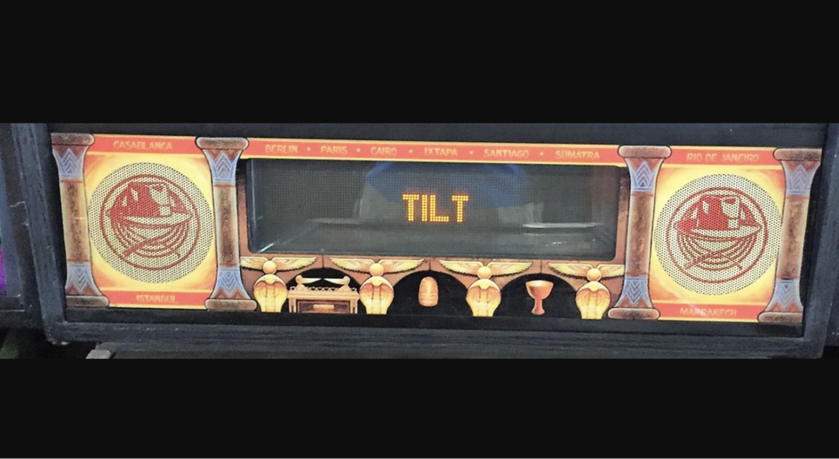 Экран ретро игрового автомата и надпись TILT