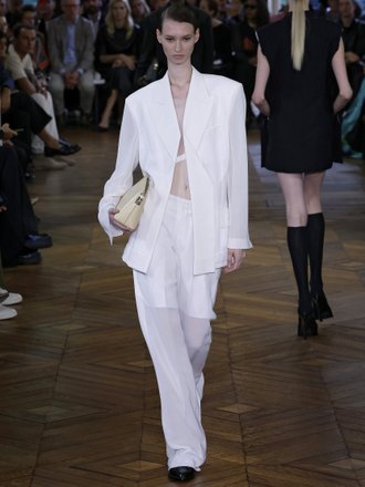 Модель в костюме с прозрачными брюками на показе Victoria Beckham