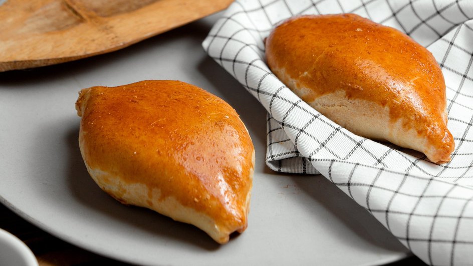 Вкусные постные пирожки с яблоками лежат на тарелке