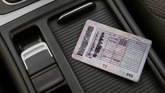 Водительские права с категорией A и B на центральном тоннеле в автомобиле