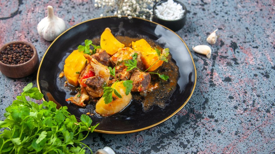 Рагу из курицы, картошки и капусты лежит на тарелке