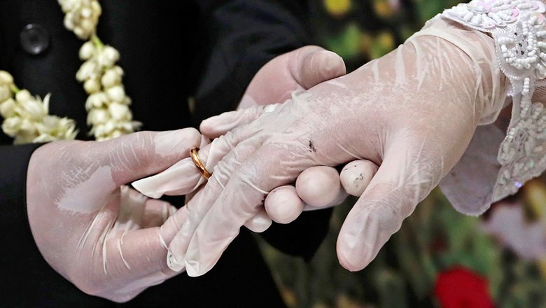 Жених Октавиан Кристианто и Невеста Эльма Дияни обмениваются кольцами во время свадебной церемонии в местном офисе по делам религий в Памуланге, на окраине Джакарты, Индонезия