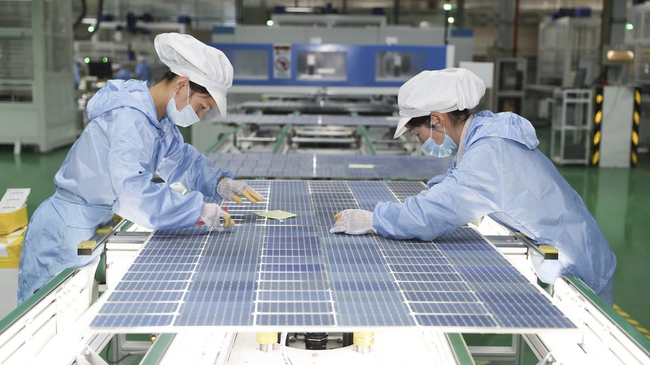Сотрудники работают на производственной линии солнечных панелей на заводе в Китае