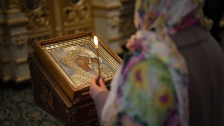 Девушка со свечой в церкви в Михайлов день.