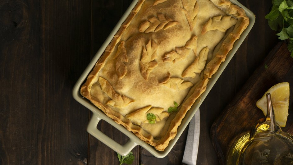 Кулебяка с капустой и грибами лежит в блюде на столе