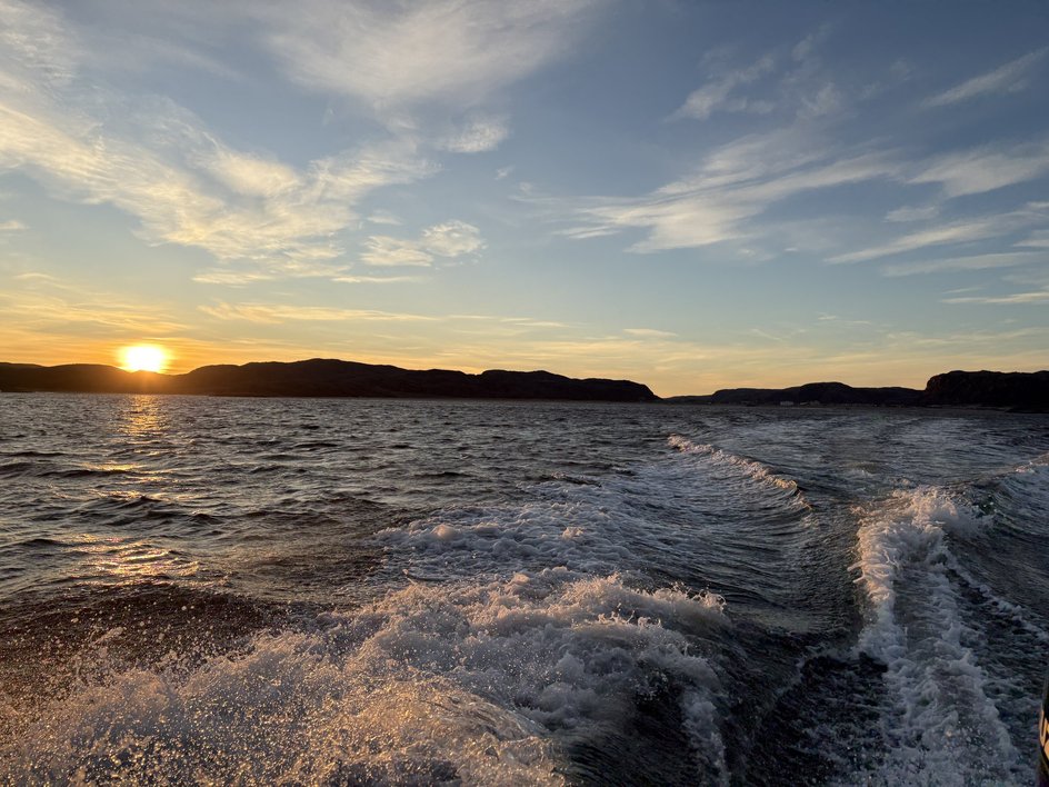 Следы от катера на воде Баренцева моря на закате