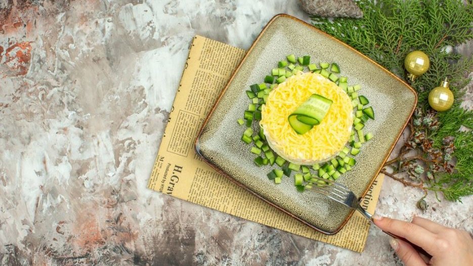 Салат с шампиньонами, ананасами, зеленью на серой тарелке Салат с шампиньонами, ананасами, зеленью на серой тарелке