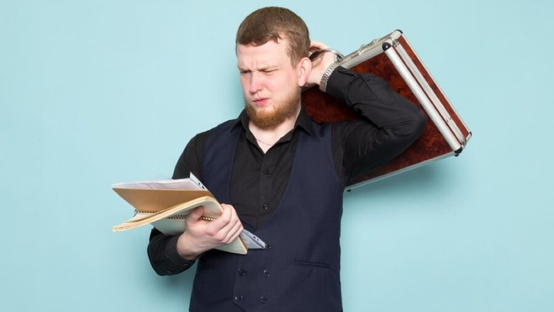 Мужчина стоит с портфелем в руках и документами, в которых указано, что счета компании заблокирован.
