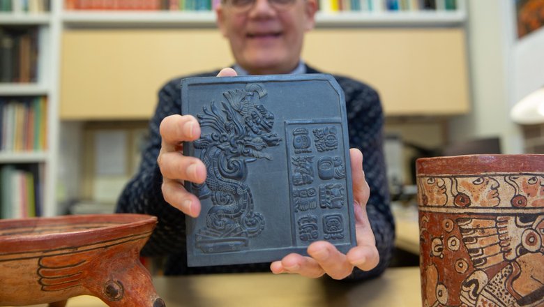 Профессор Калифорнийского университета Дэвид Ленц держит скульптуру, на которой изображены репродукции древних символов майя. 