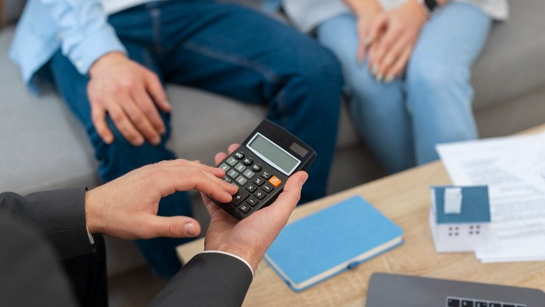 Мужчина и женщине рассчитывают на калькуляторе налог с продажи квартиры. Мужчина и женщине рассчитывают на калькуляторе налог с продажи квартиры.