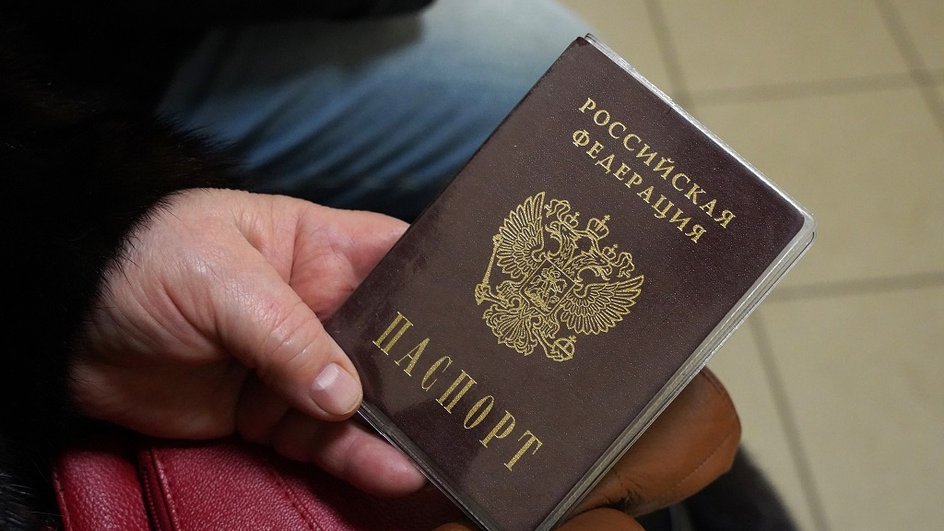 Мужчина держит в руках паспорт