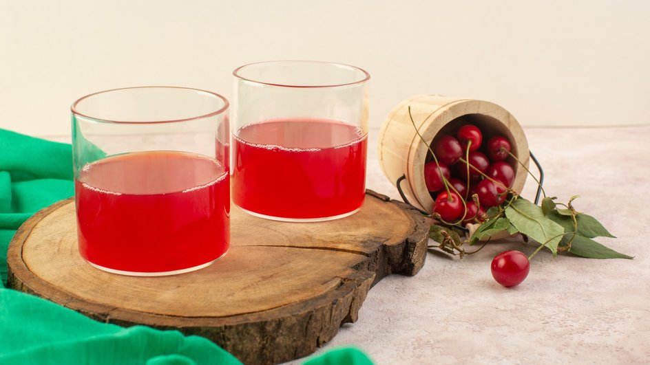 Компот из клубники и вишни в стеклянных стаканах на деревянной доске Компот из клубники и вишни в стеклянных стаканах на деревянной доске