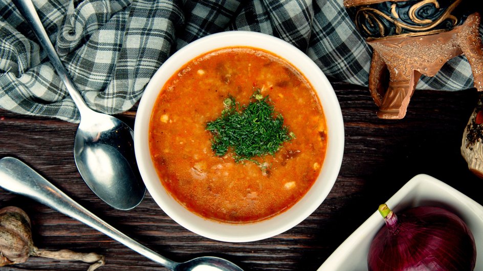 Тарелка фасолевого супа с курицей стоит на столе Тарелка фасолевого супа с курицей стоит на столе