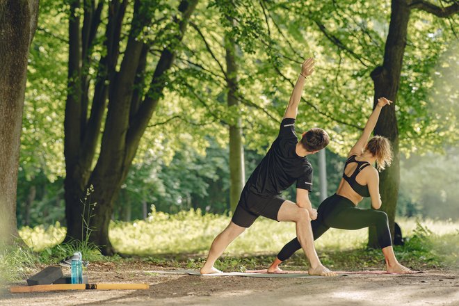 Пара занимается спортом летом в парке Пара занимается спортом летом в парке