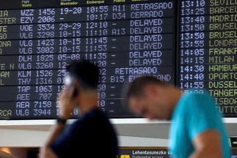Пассажиры ждут перед табло с информацией о задержке рейсов в аэропорту Бильбао в Бильбао