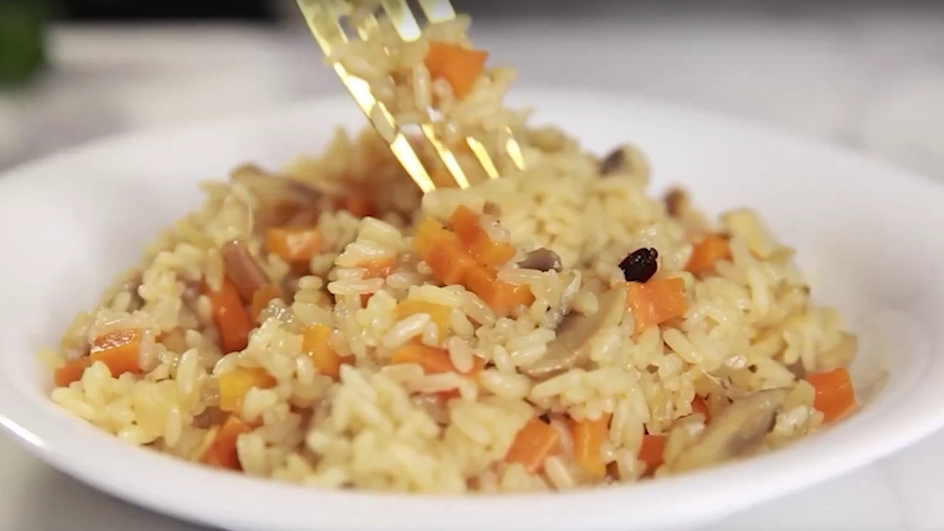 Постный плов с овощами, приготовленный в мультиварке, лежит на тарелке