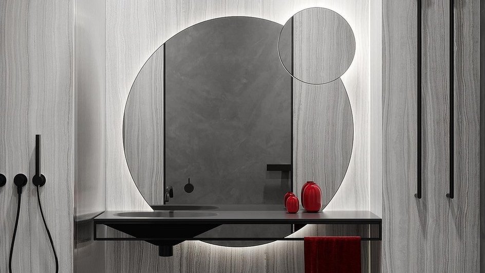 Зеркало с подсветкой в ванной комнате на фоне серой стены
