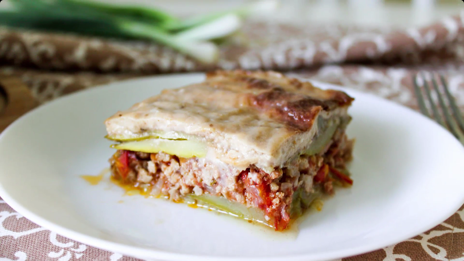 Кусочек мусаки с кабачками лежит на тарелке Кусочек мусаки с кабачками лежит на тарелке