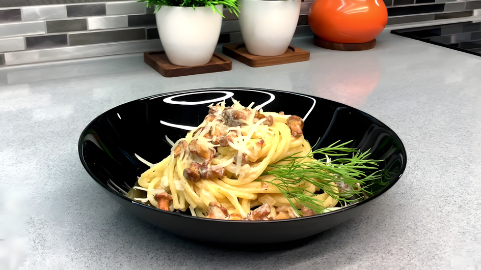 Тарелка пасты с лисичками и курицей стоит на столе Тарелка пасты с лисичками и курицей стоит на столе