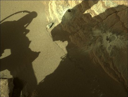 На первом фото показан образец марсианского грунта. На втором — отверстие, которое проделал марсоход, чтобы собрать его. Фото: NASA