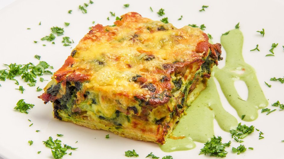 Кусочек кабачковой запеканки с рисом и брокколи лежит на тарелке Кусочек кабачковой запеканки с рисом и брокколи лежит на тарелке