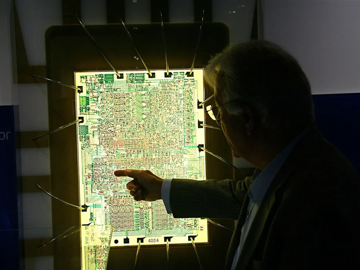 Фредерико Фаггин указывает на увеличенное изображение микропроцессора Intel 4004 Фредерико Фаггин указывает на увеличенное изображение микропроцессора Intel 4004