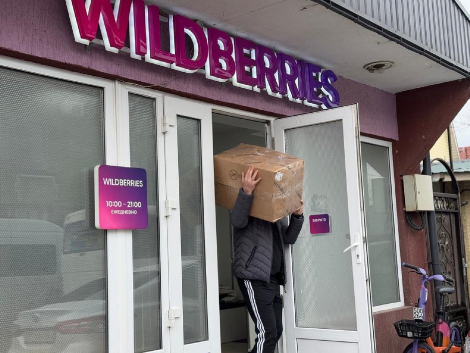 мужчина выносит коробку из Wildberries мужчина выносит коробку из Wildberries