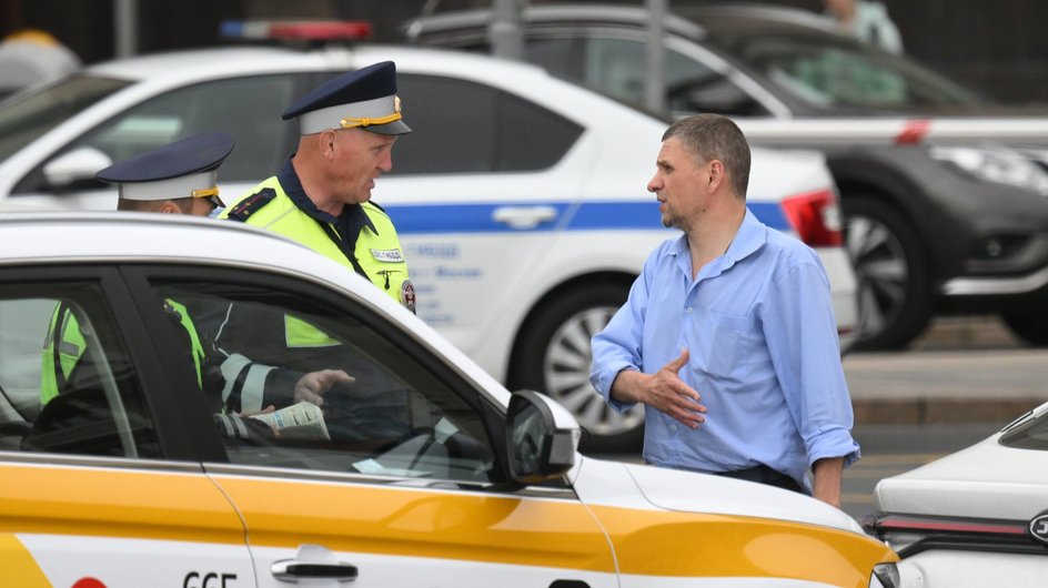 Сотрудники ГИБДД общаются с автовладельцем в центре Москвы