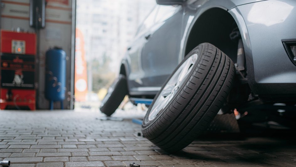 Автомобиль на шиномонтаже меняет колеса Автомобиль на шиномонтаже меняет колеса