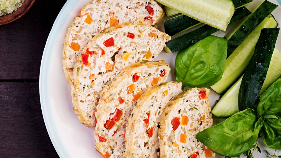 Куриное суфле лежит на тарелке с огурцами Куриное суфле лежит на тарелке с огурцами