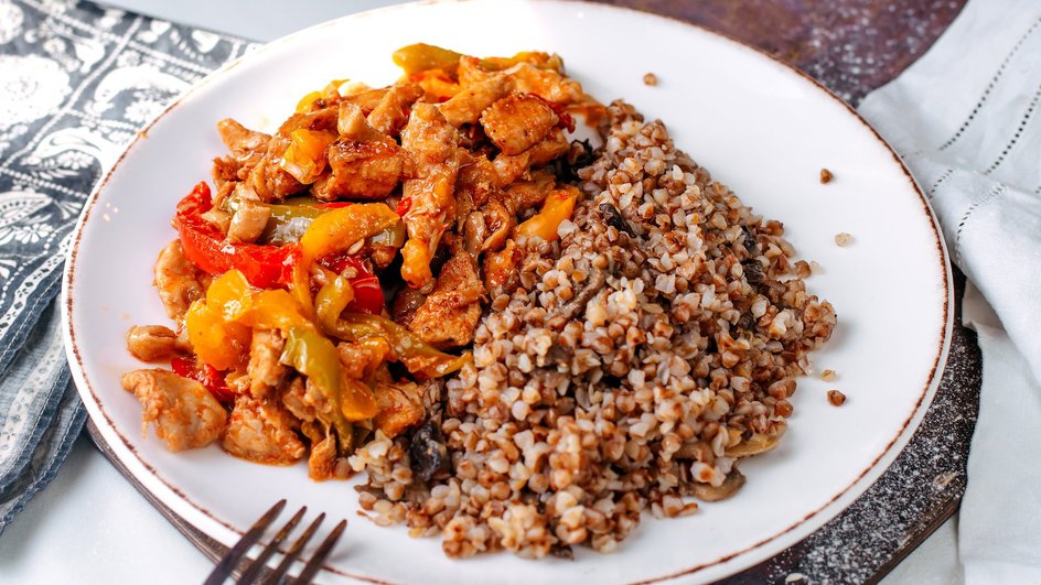 Курица с овощами и гречкой на тарелке Курица с овощами и гречкой на тарелке