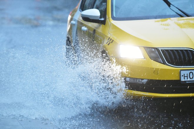 Автомобиль такси на дороге во время сильного дождя в Москве