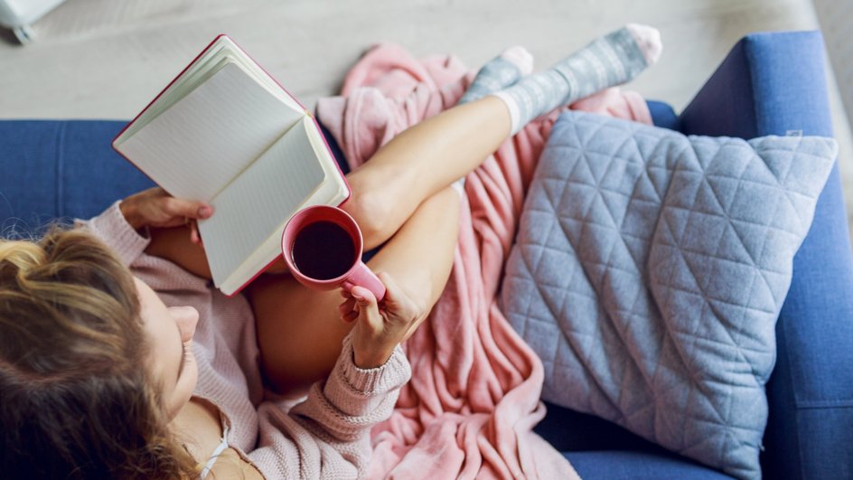 Девушка-Близнецы отдыхает дома с книгой и чашкой чая Девушка-Близнецы отдыхает дома с книгой и чашкой чая