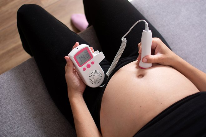 Женщина отслеживает сердцебиение плода Женщина отслеживает сердцебиение плода