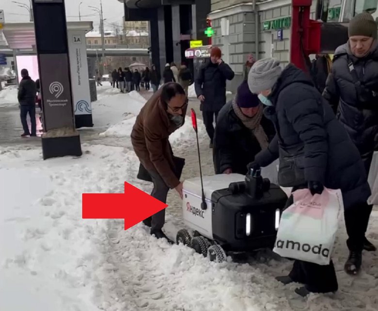 Москвичи помогают роботу выбраться из снега. Фото: Telegram-канал «Новости Москвы»